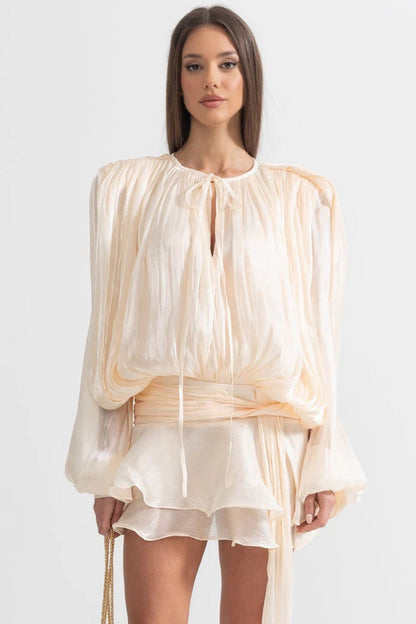 Elegant women's pleated chiffon mini dress in soft peach tones, perfect for summer events and formal occasions.
