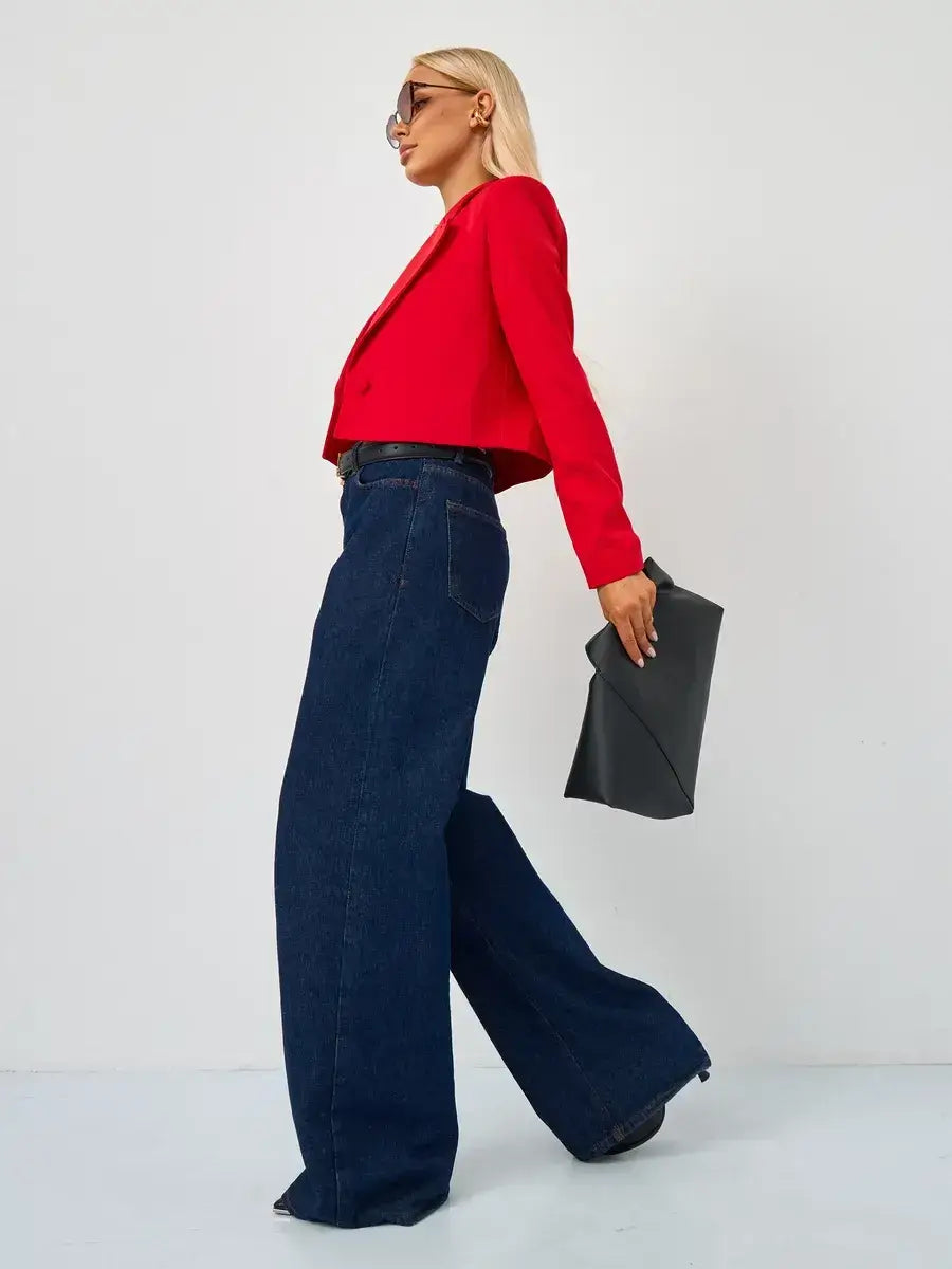 Stylish model wearing a Ruby Blazer by Lauven with wide-leg jeans, showcasing vibrant red tailored elegance.