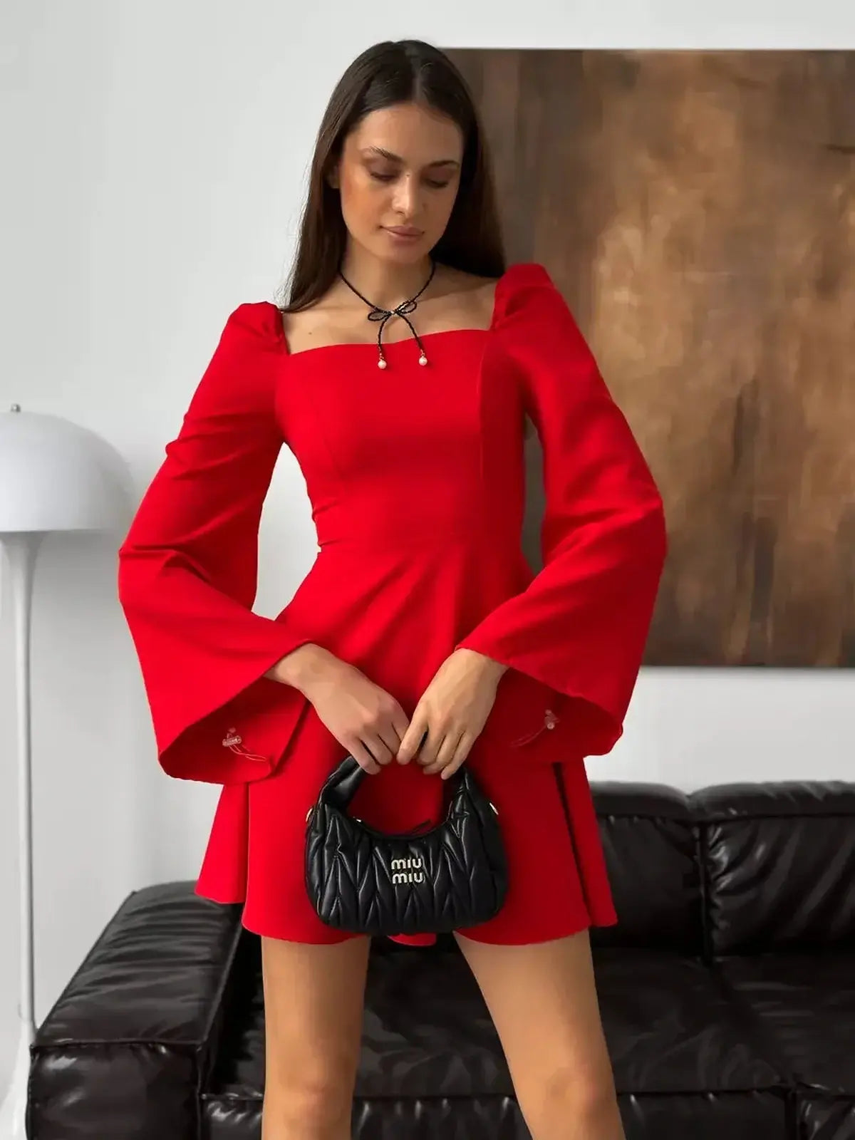 Stylish woman in a red mini dress with puff sleeves and square neckline, perfect for weddings and formal events.