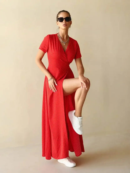 Model showcasing the Ruby Grace Maxi Dress in red polka dots, featuring a V-neckline and stylish side slit.