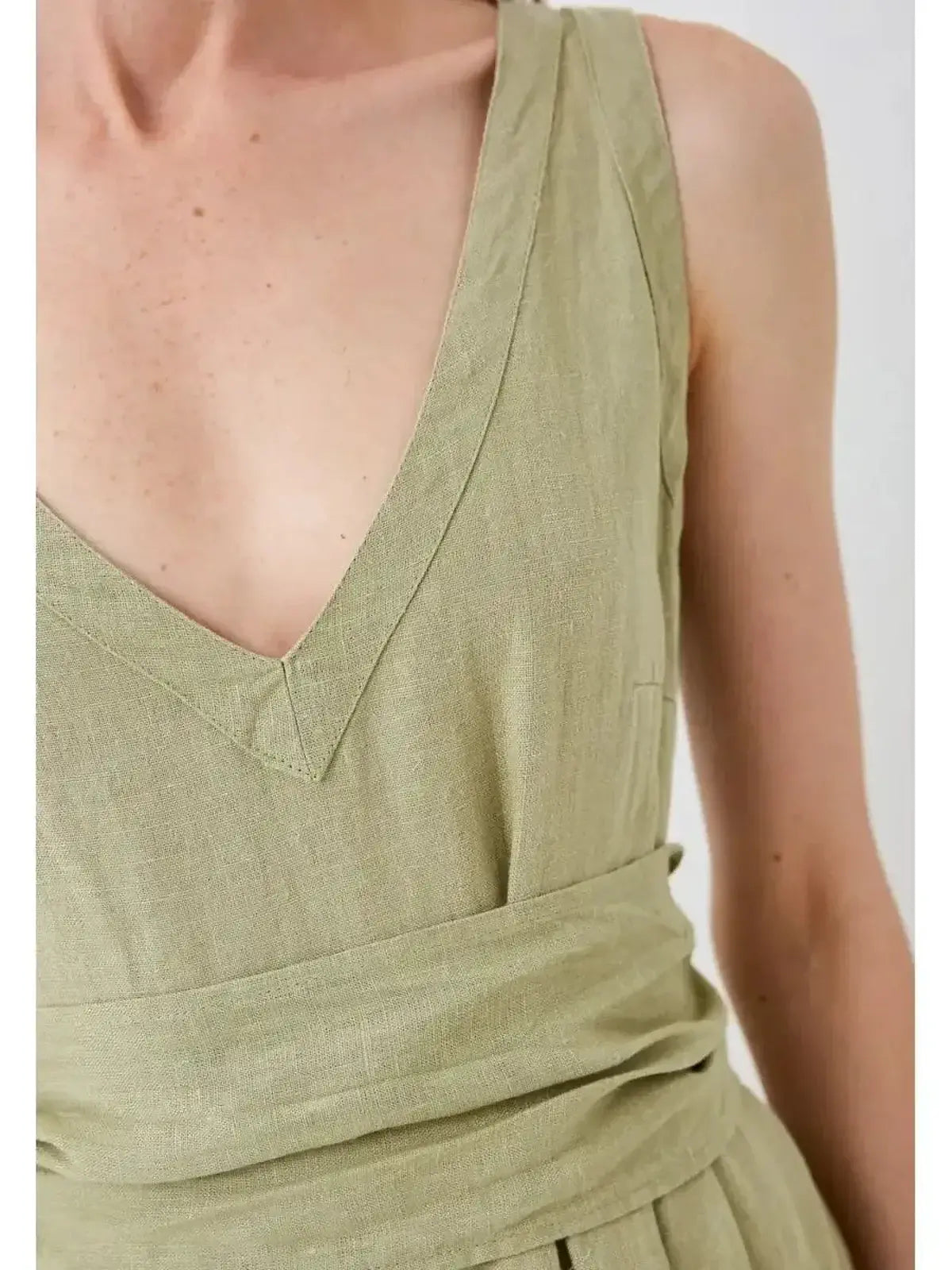 Close-up of the Sage Whisper Maxi Dress, showcasing its V-neckline and elegant wrap-style belt in lightweight linen.