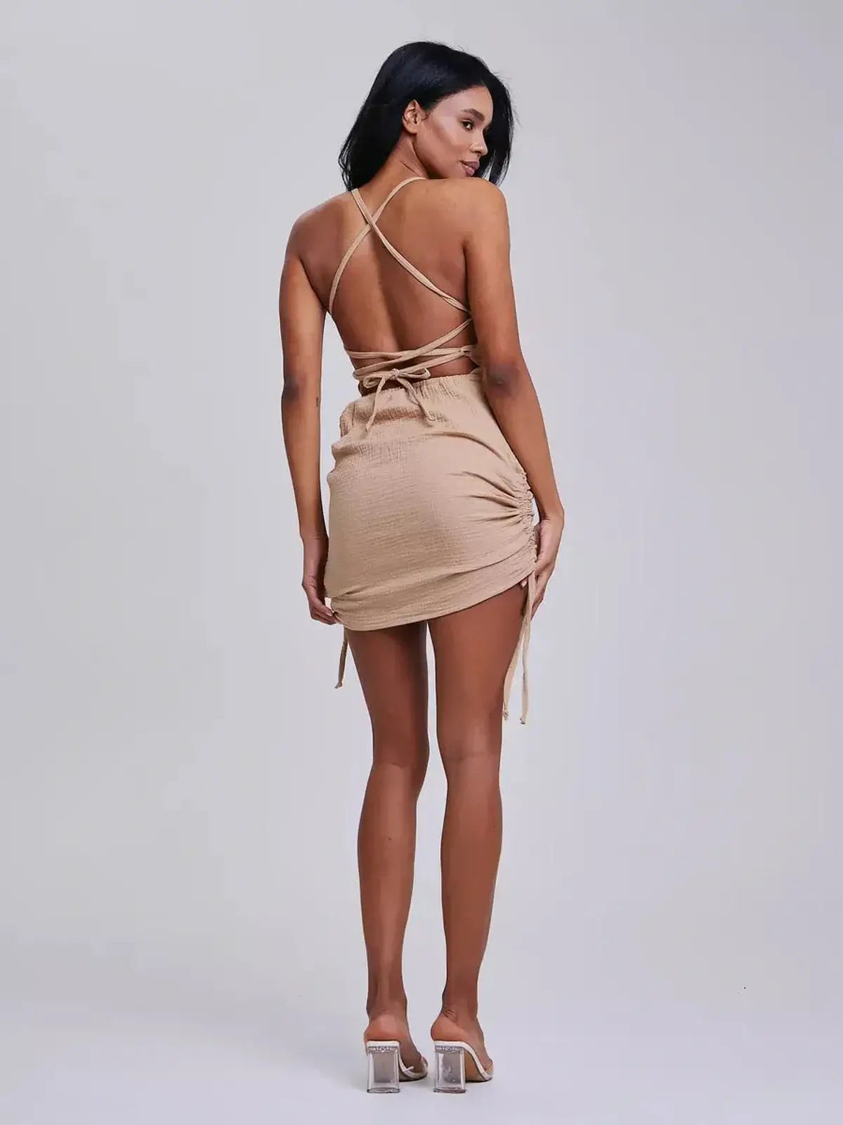 Sahara Strings mini dress by Lauven, featuring an open back and ruched sides for a flattering fit.