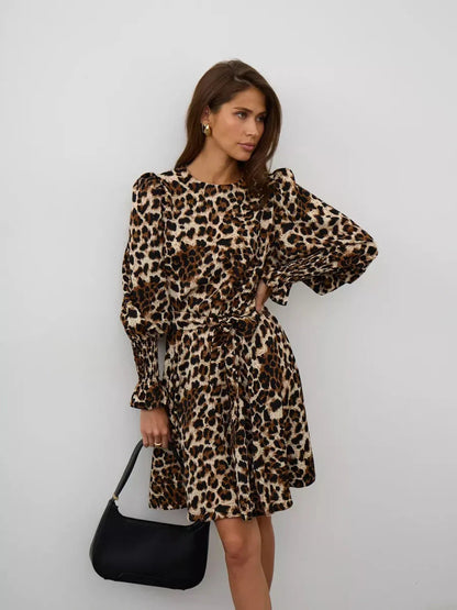 Savannah Mini Dress in leopard print with long sleeves and tie belt, exuding bold style and effortless allure.