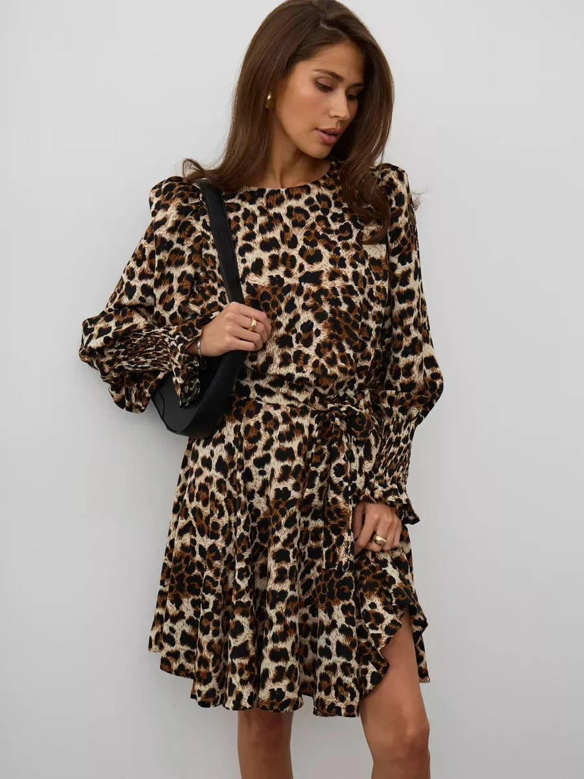 Savannah Mini Dress featuring a bold leopard print, ruffles, and a waist-defining tie belt for an elegant look.