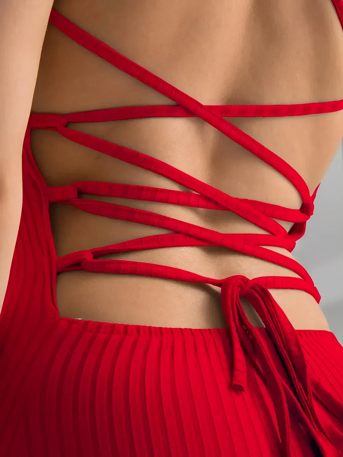 Close-up of the back of the Scarlet Lace Midi Dress featuring a corset-style lace-up design in vibrant red.