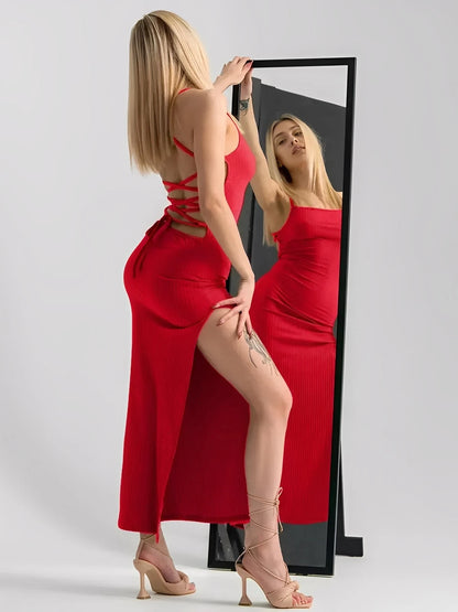 Model showcasing the Scarlet Lace Midi Dress with corset back and side slit, in a vibrant red hue, posed by a mirror.