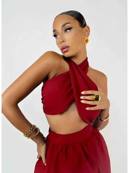 Model showcases the Scarlet Mirage Set, featuring a draped halter top and high-waisted skirt in elegant crimson.