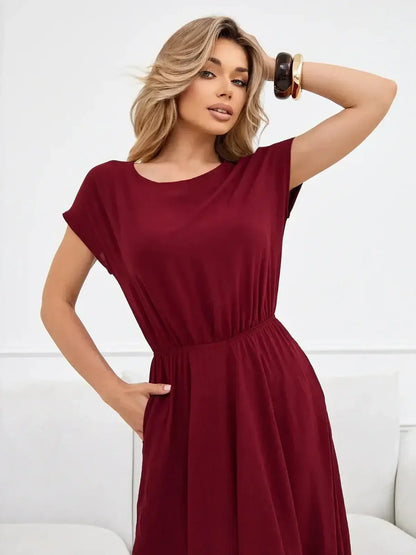 Model wearing the Sculpted Ease Maxi Dress in deep burgundy, showcasing its airy fit and cinched waist design.