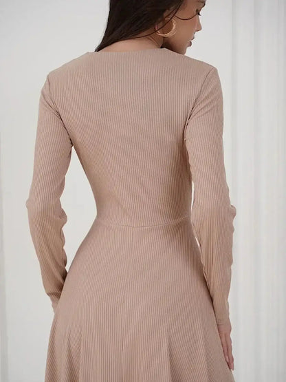 Back view of a woman wearing the Sculpted Ease Midi Dress by Lauven in a smooth beige ribbed knit.