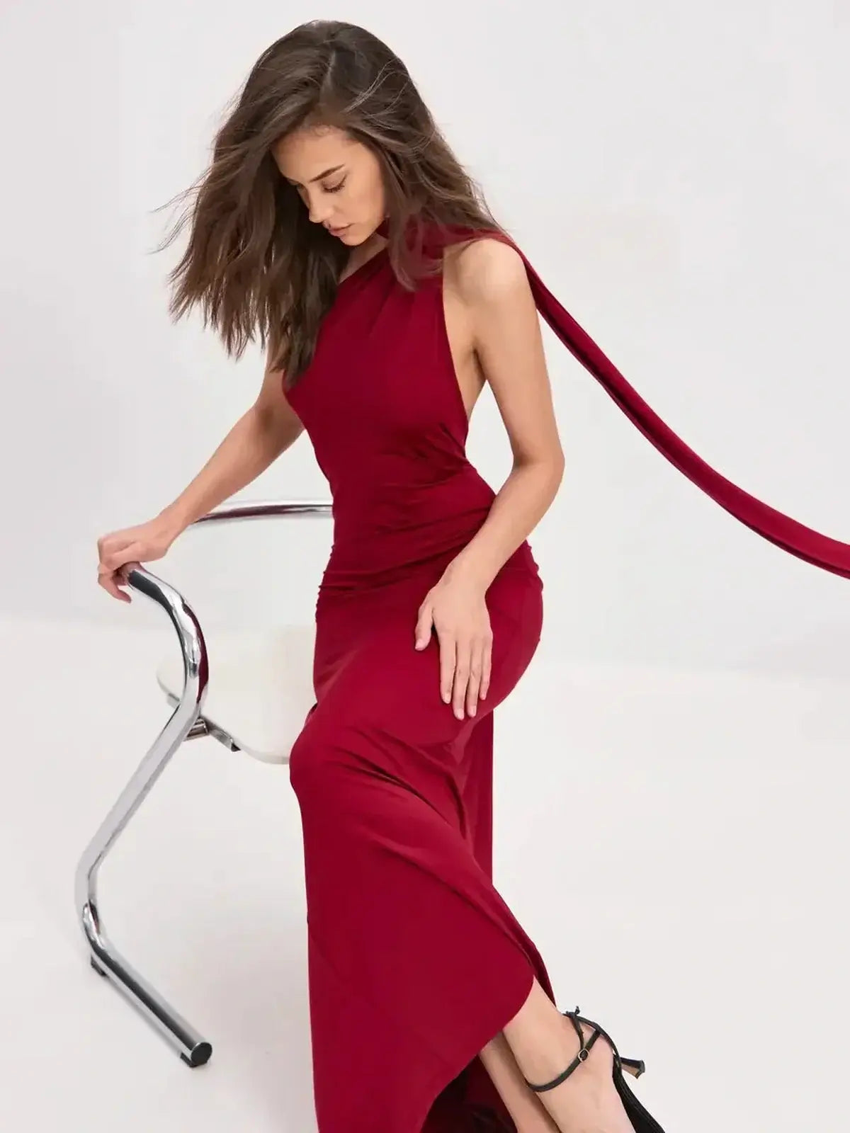 Model wearing a Sculpted Flame Maxi Dress in bold red, featuring a sleek one-shoulder design and flowing scarf detail.