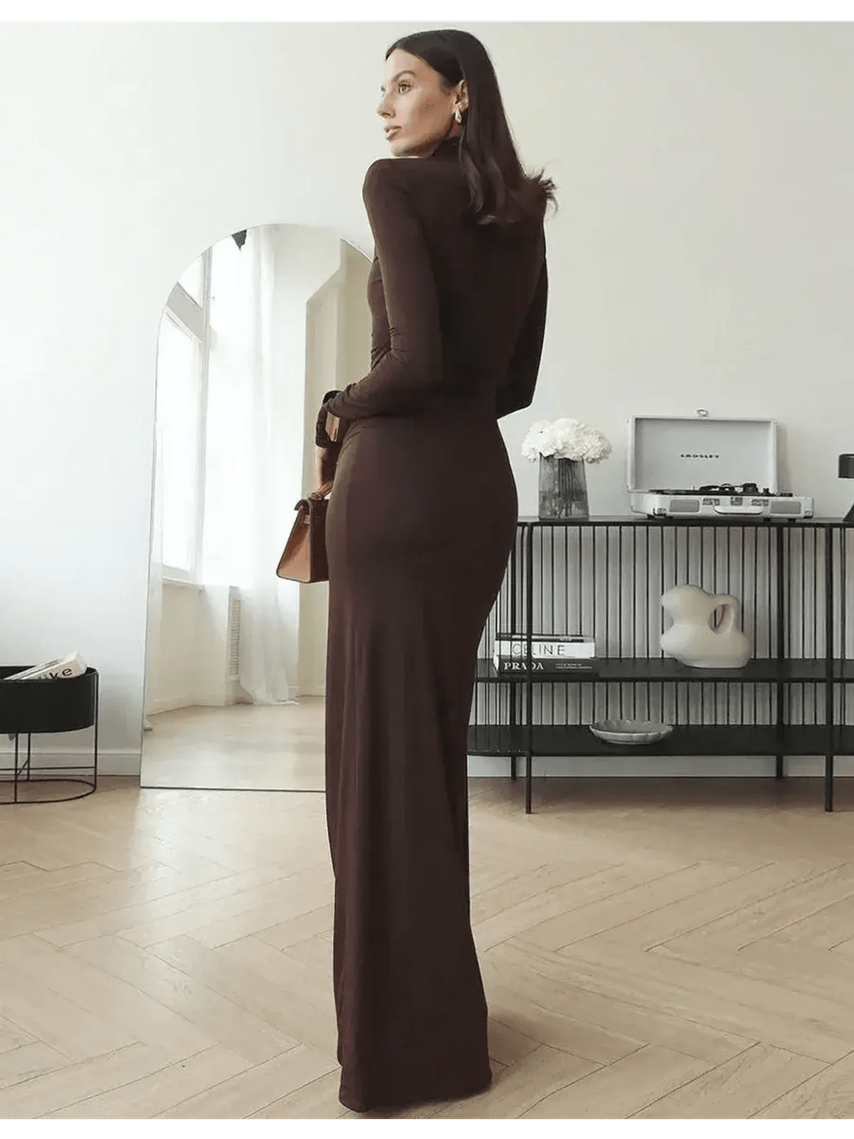 Elegant Sculpted Grace Maxi Dress in rich chocolate brown, showcasing a sleek silhouette with draped detailing in a modern setting.
