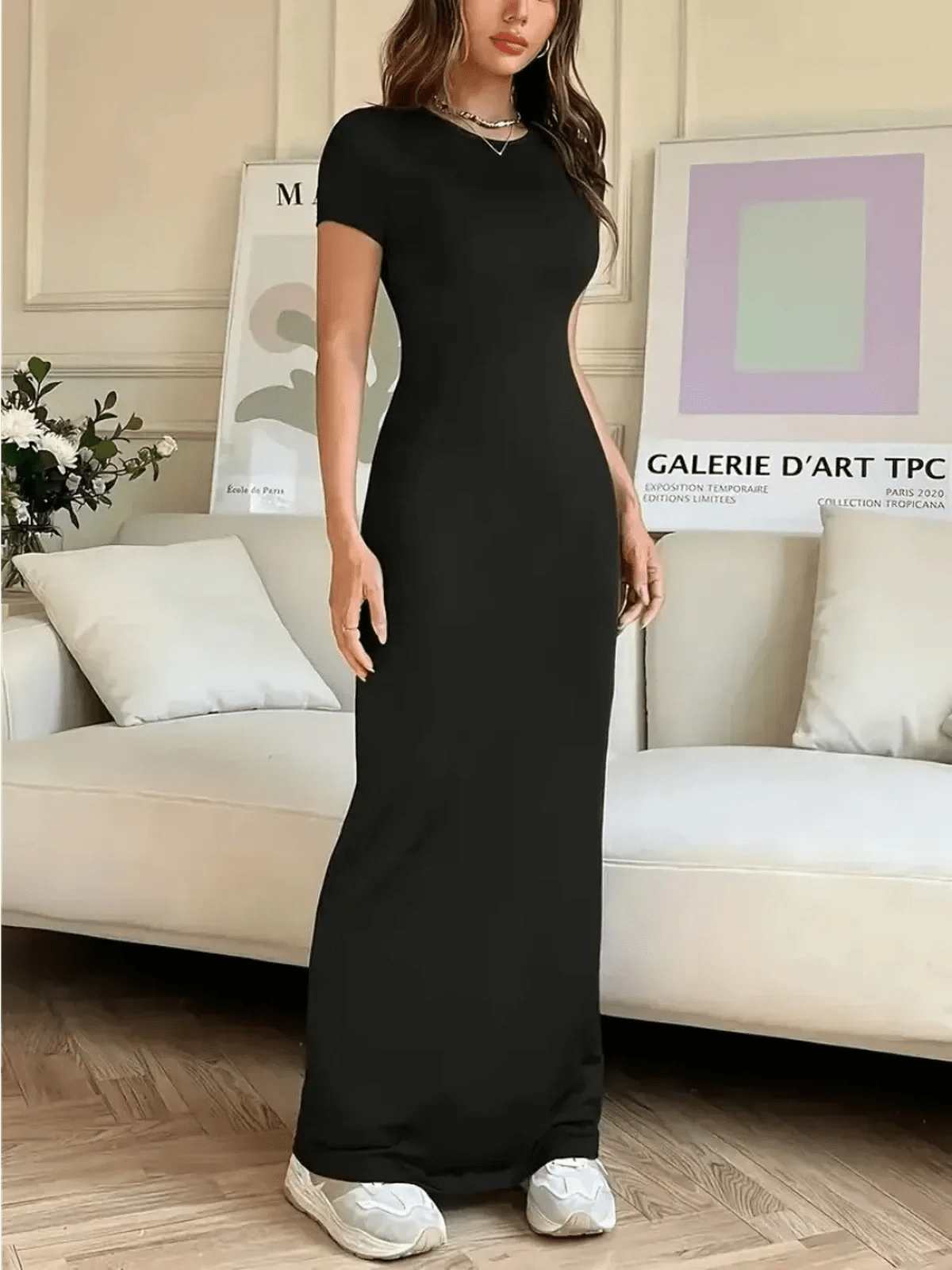 Sculpted Grace Maxi Dress in black, showcasing a sleek silhouette against a modern, stylish interior.