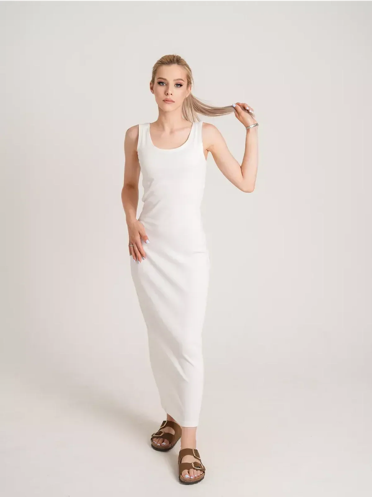 Model showcasing the Sculptura Maxi Dress in white, highlighting its sleek ribbed elegance and comfortable fit.