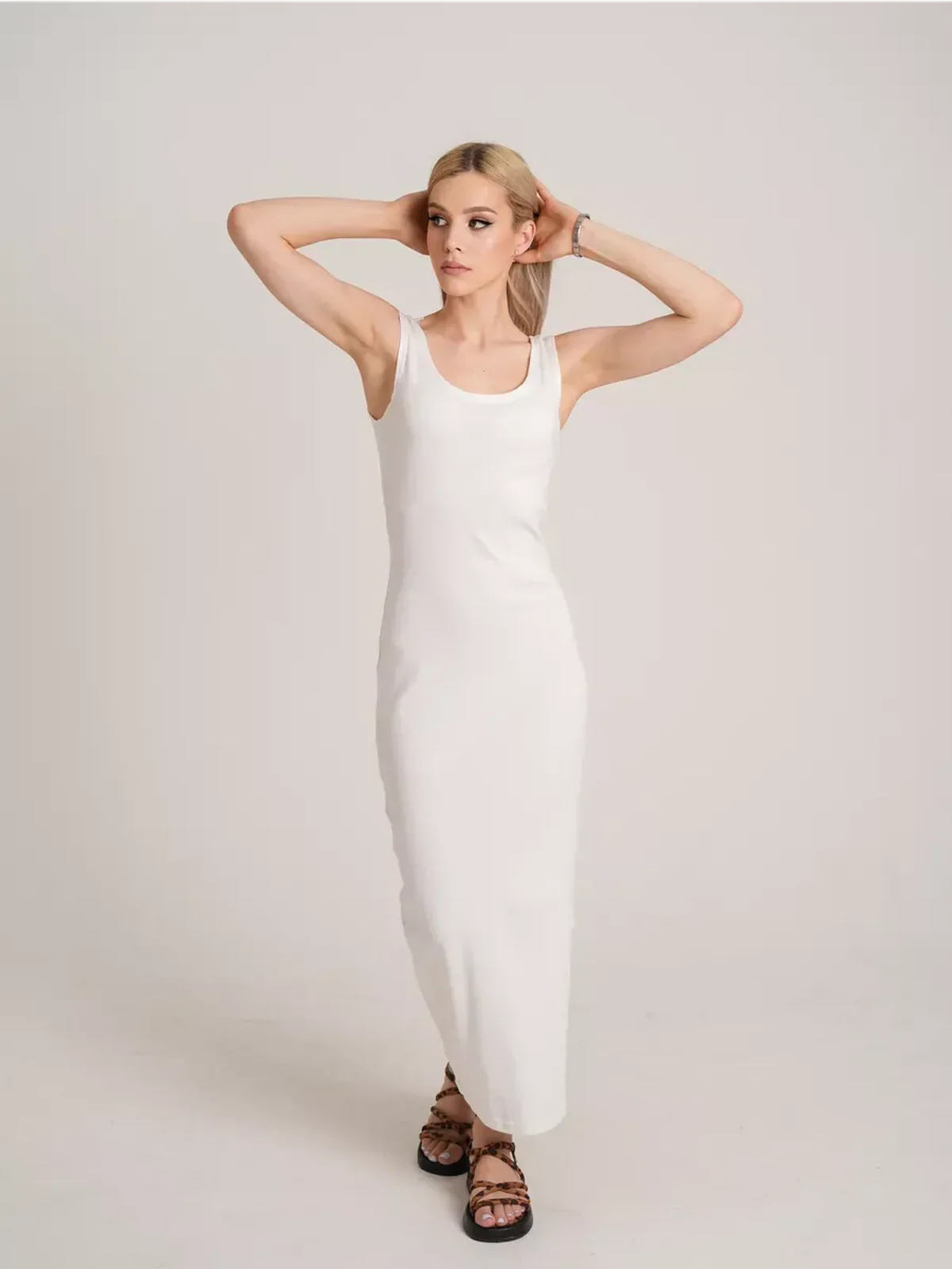 Model showcasing the Sculptura Maxi Dress in white, embodying sleek ribbed elegance and contemporary minimalism.