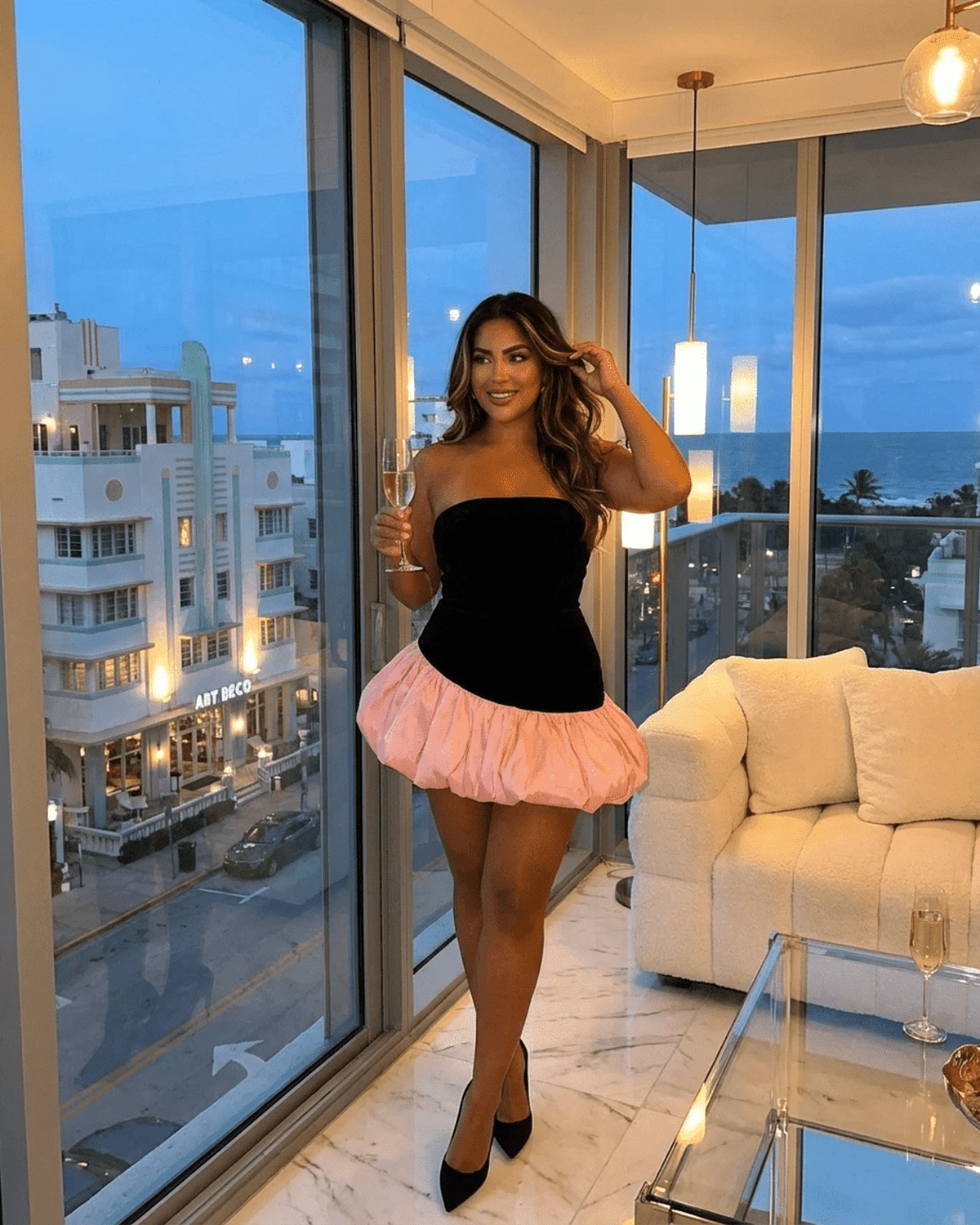 Model showcasing the Selina Mini Dress by Lauven, featuring a strapless velvet bodice and playful pink puff skirt.