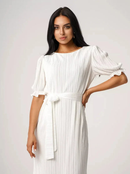 Model wearing Seraphine Maxi Dress, showcasing pleated elegance and refined silhouette in a lightweight, white fabric.