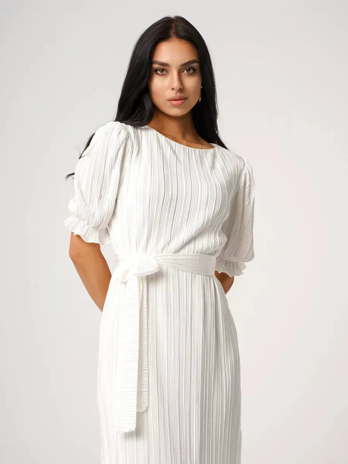 Model showcasing the Seraphine Maxi Dress, featuring pleats, a flattering silhouette, and elegant puff sleeves in white.