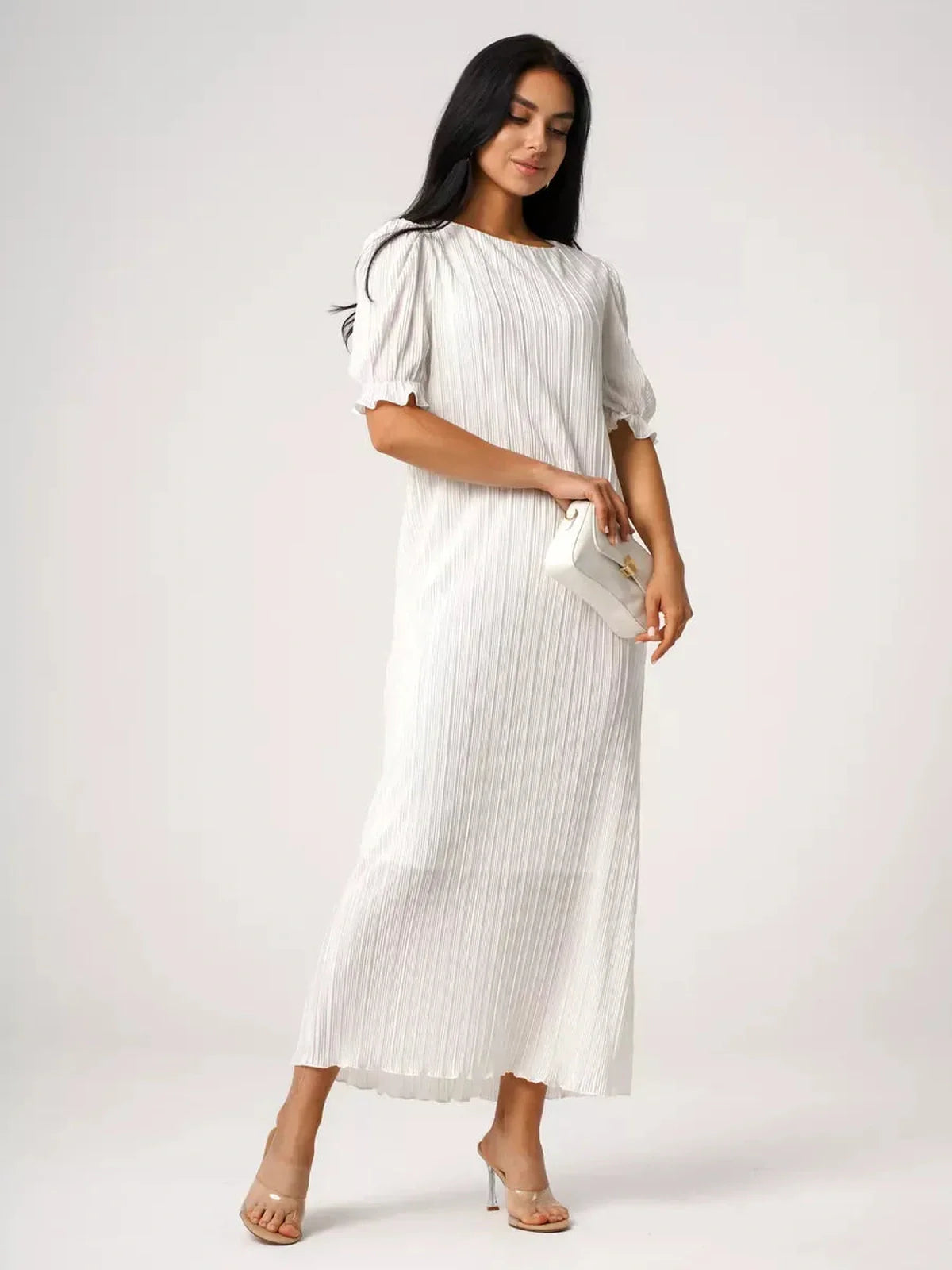 Model wearing Seraphine Maxi Dress, showcasing pleated elegance and refined silhouette in white.