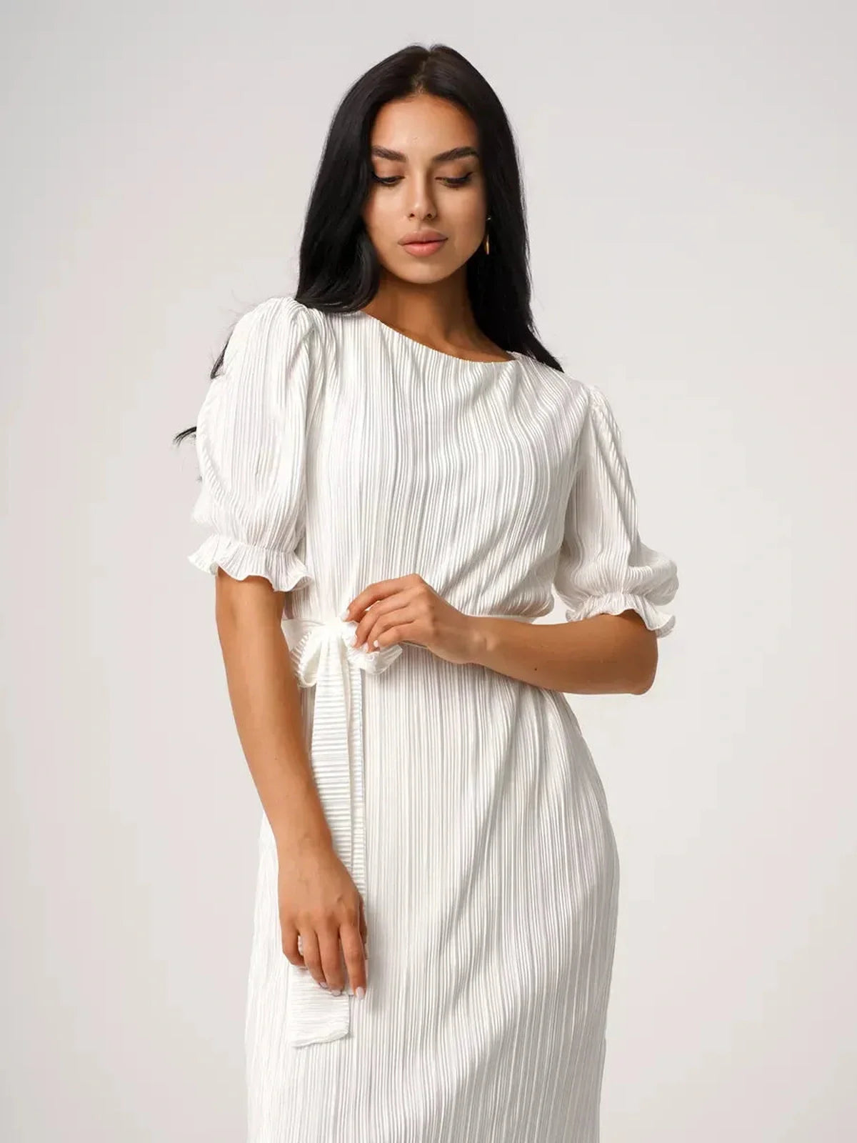 Model showcasing the Seraphine Maxi Dress, featuring pleated fabric and elegant puff sleeves, perfect for summer events.