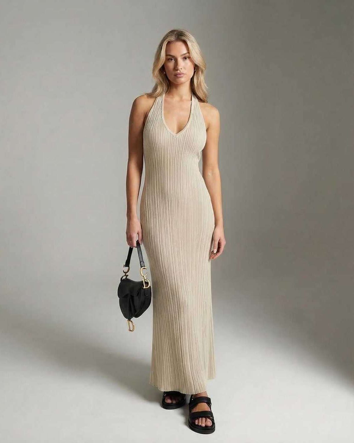 Model wearing the Serena Maxi Dress by Lauven, a sleek V-neck ribbed knit ankle-length dress in beige.