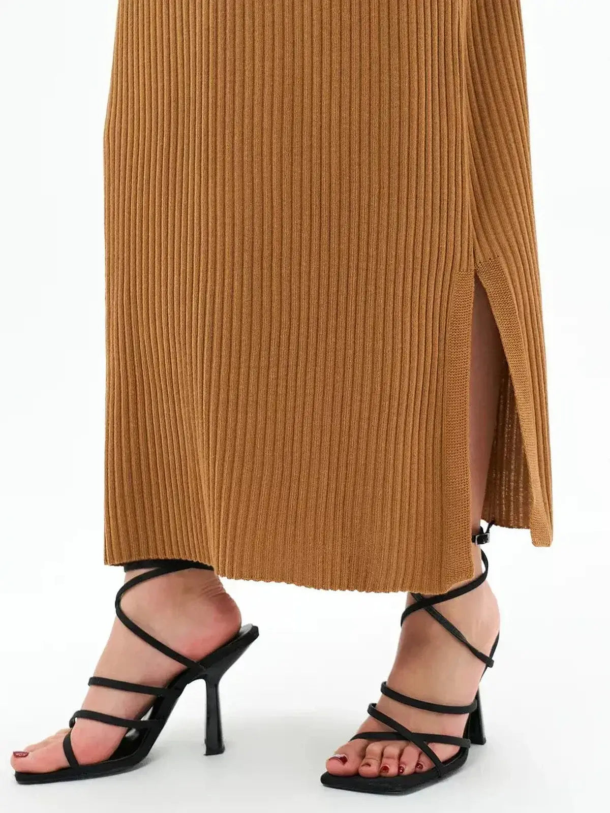 Close-up of the side slit of the Serena Maxi Dress in ribbed fabric, paired with strappy black heels.
