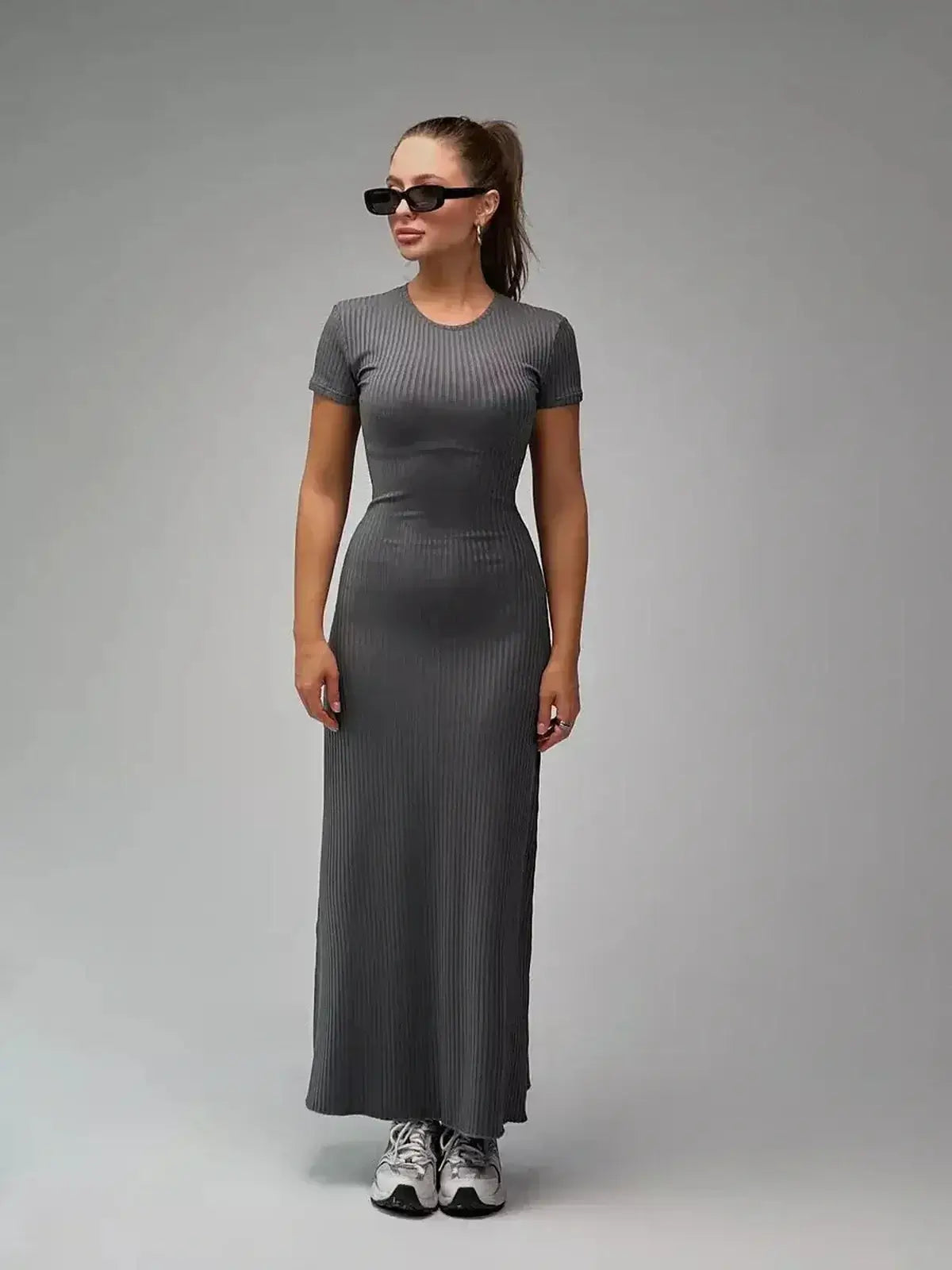 Model wearing the Shadow Curve Maxi Dress in a sleek gray ribbed knit, perfect for summer or casual occasions.