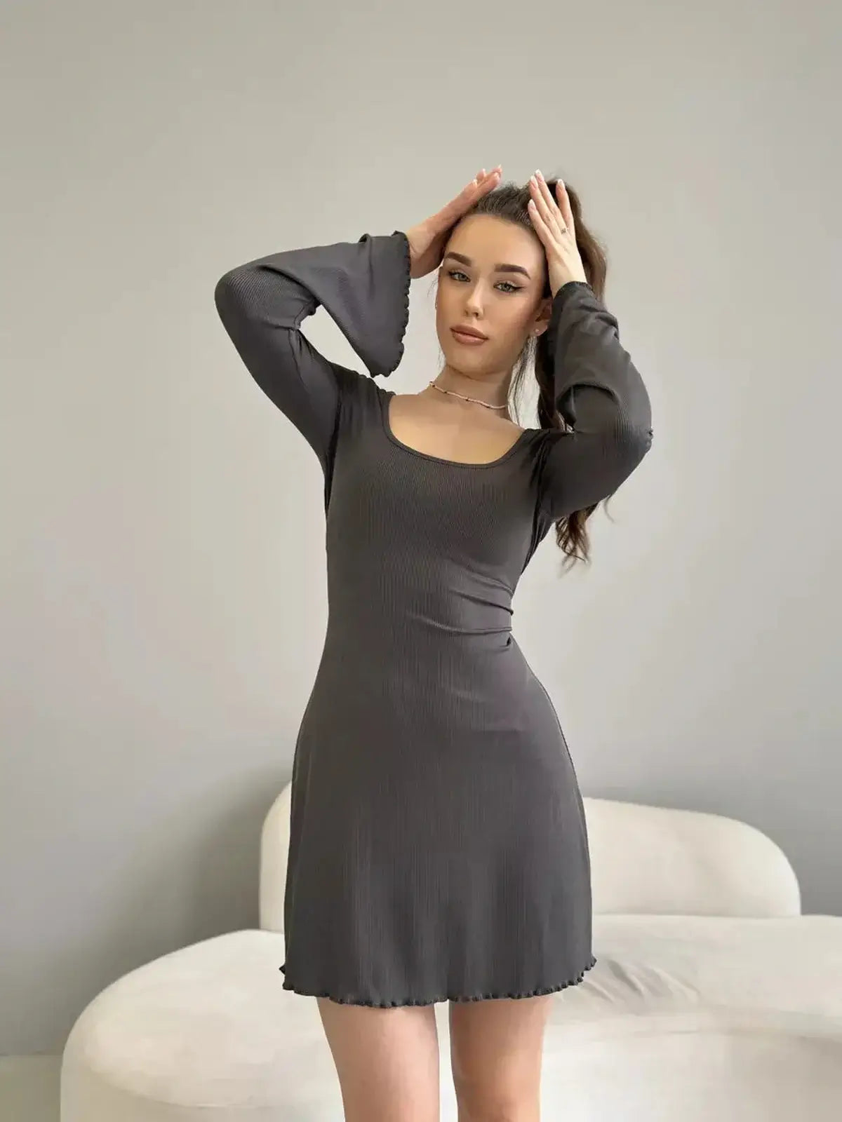 Model showcasing the elegant Shadow Flare mini dress with bell sleeves in dark grey, perfect for summer and evening events.