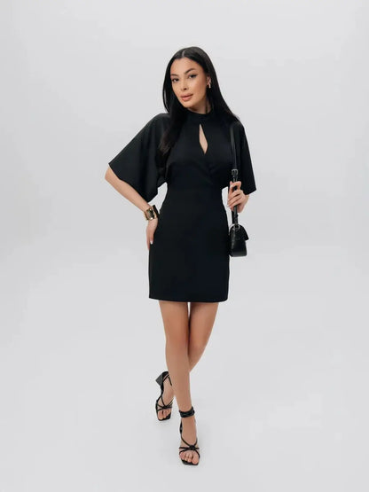 Model wearing the Shadow Grace black mini dress with sculpted silhouette and winged short sleeves.