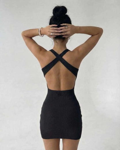 Back view of a model wearing the Lauven Sienna Mini Dress in black ribbed knit, showcasing its sleek sleeveless design.