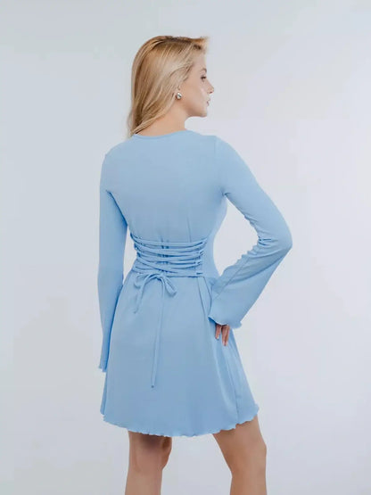 Back view of Sky Laced baby blue mini dress with long sleeves and lace-up detailing.