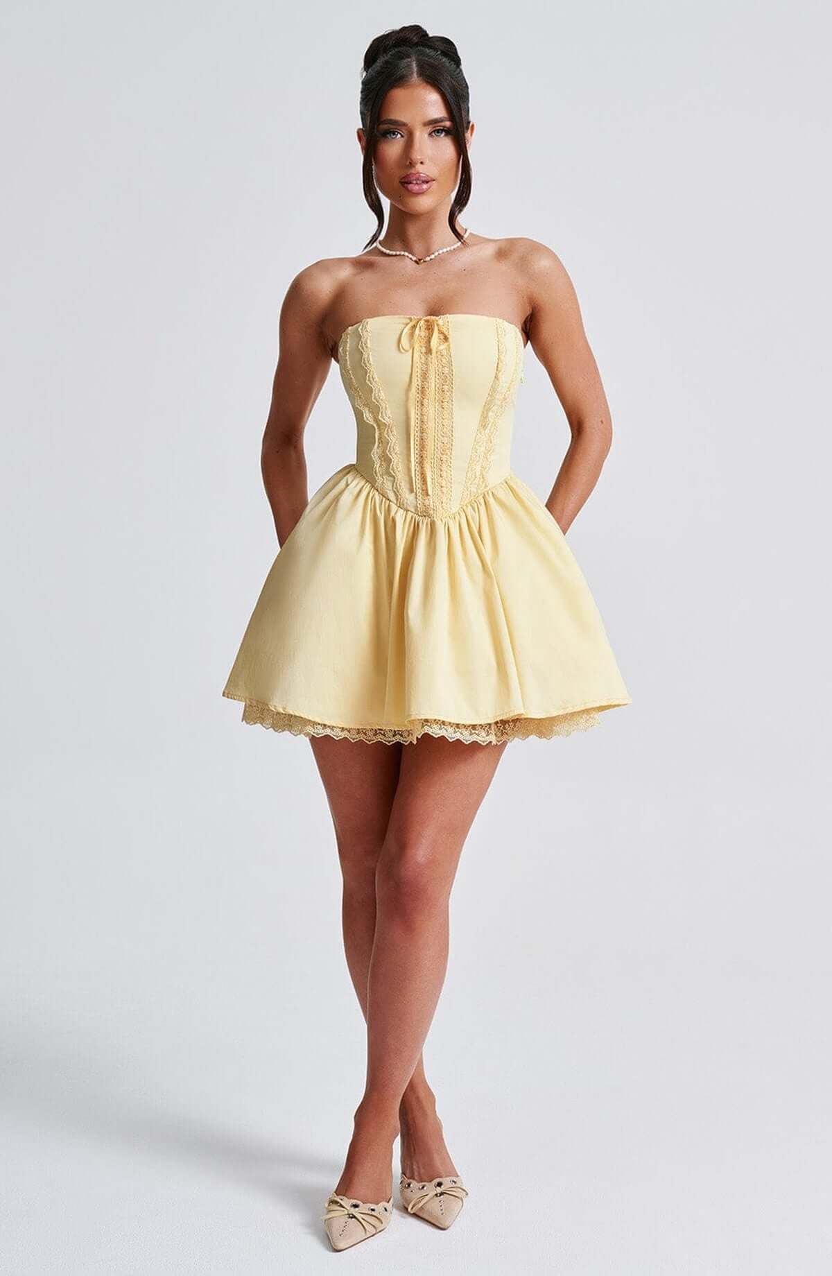 Stylish yellow Skye Mini Dress featuring a corset design, strapless neckline, and lace detailing, perfect for summer parties.