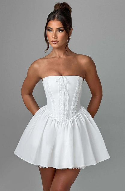 White strapless mini dress with corset design, featuring a flared skirt for a romantic look, ideal for summer or wedding guests.