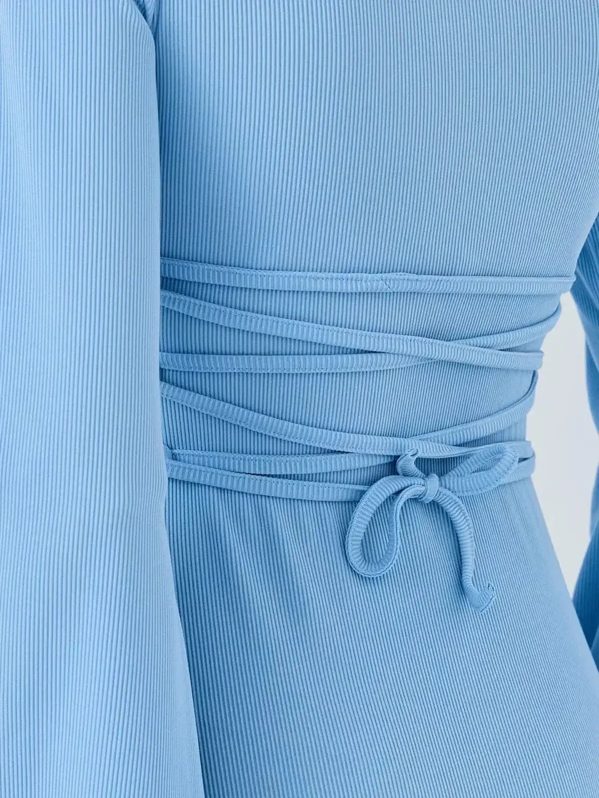 Close-up of Skyline Flare long sleeve dress showcasing its ribbed fabric and waist tie detail for a flattering fit.