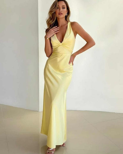Elegant model wearing the Solara Maxi Dress by Lauven, a yellow satin sleeveless V-neck dress with A-line silhouette.