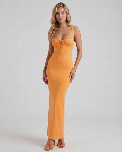 Model wearing the Soleil Maxi Dress by Lauven, a vibrant orange stretch knit with a sexy silhouette.