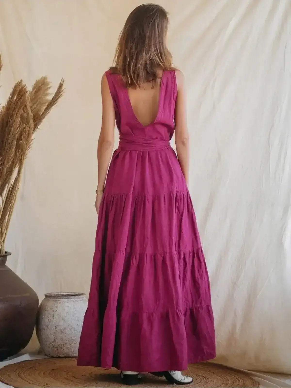 Back view of Solène Maxi Dress in vibrant pink linen, showcasing tiered design and elegant backless detail.