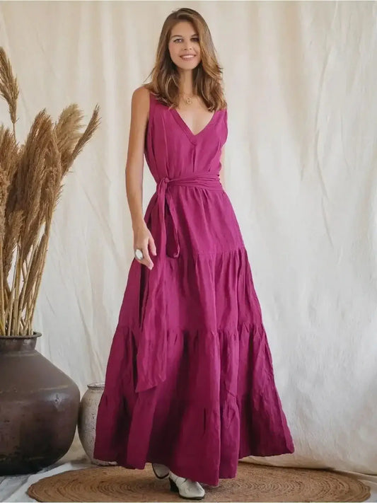 Model wearing the Solène Maxi Dress in vibrant magenta, showcasing its natural linen elegance and backless design.