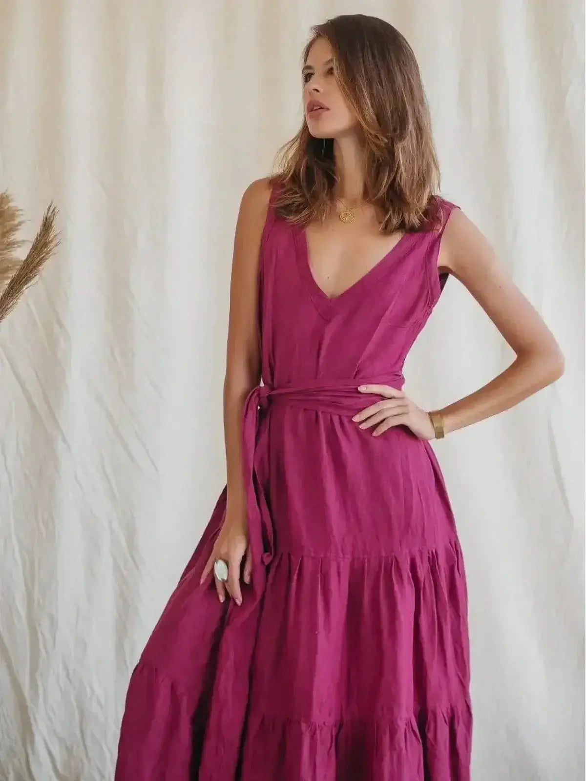 Model wearing the Solène Maxi Dress in magenta, showcasing a V-neckline and tiered design for summer elegance.