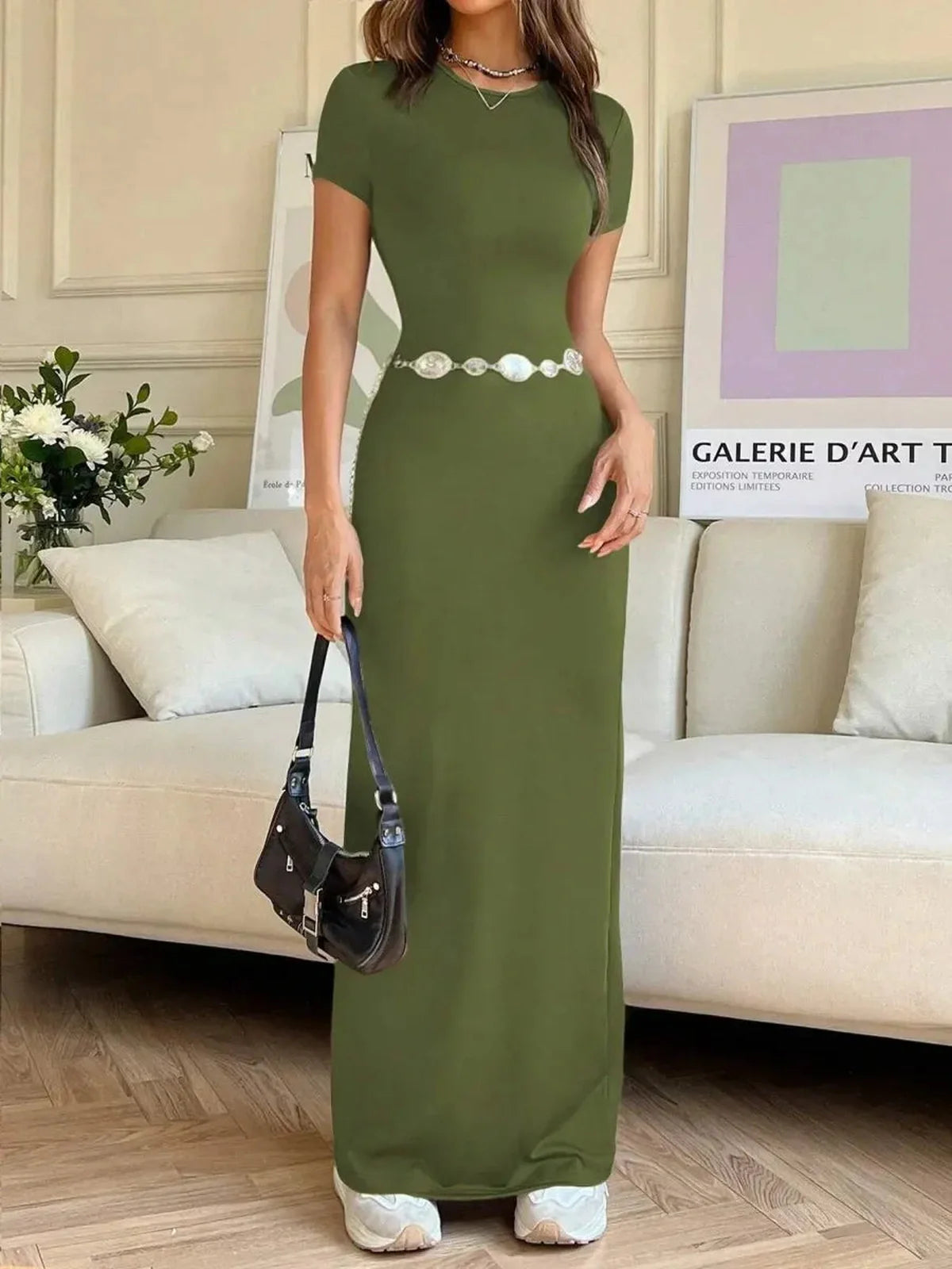 Olive green maxi dress with a sculpting silhouette, worn by a model in a stylish indoor setting.