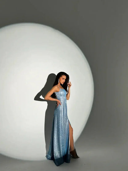 Model showcasing the Starlit Glow Maxi Dress in shimmer-blue, featuring a sculpted bodice and elegant side slit.