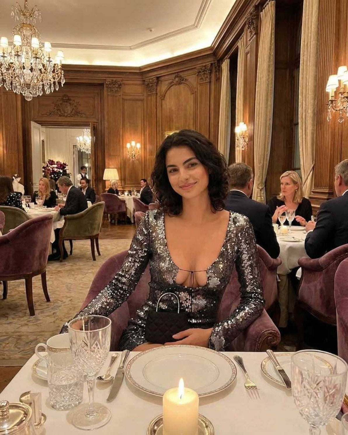 Elegant woman in Lauven Stella Mini Dress with sequined shine, flared sleeves, dining in a luxurious restaurant.