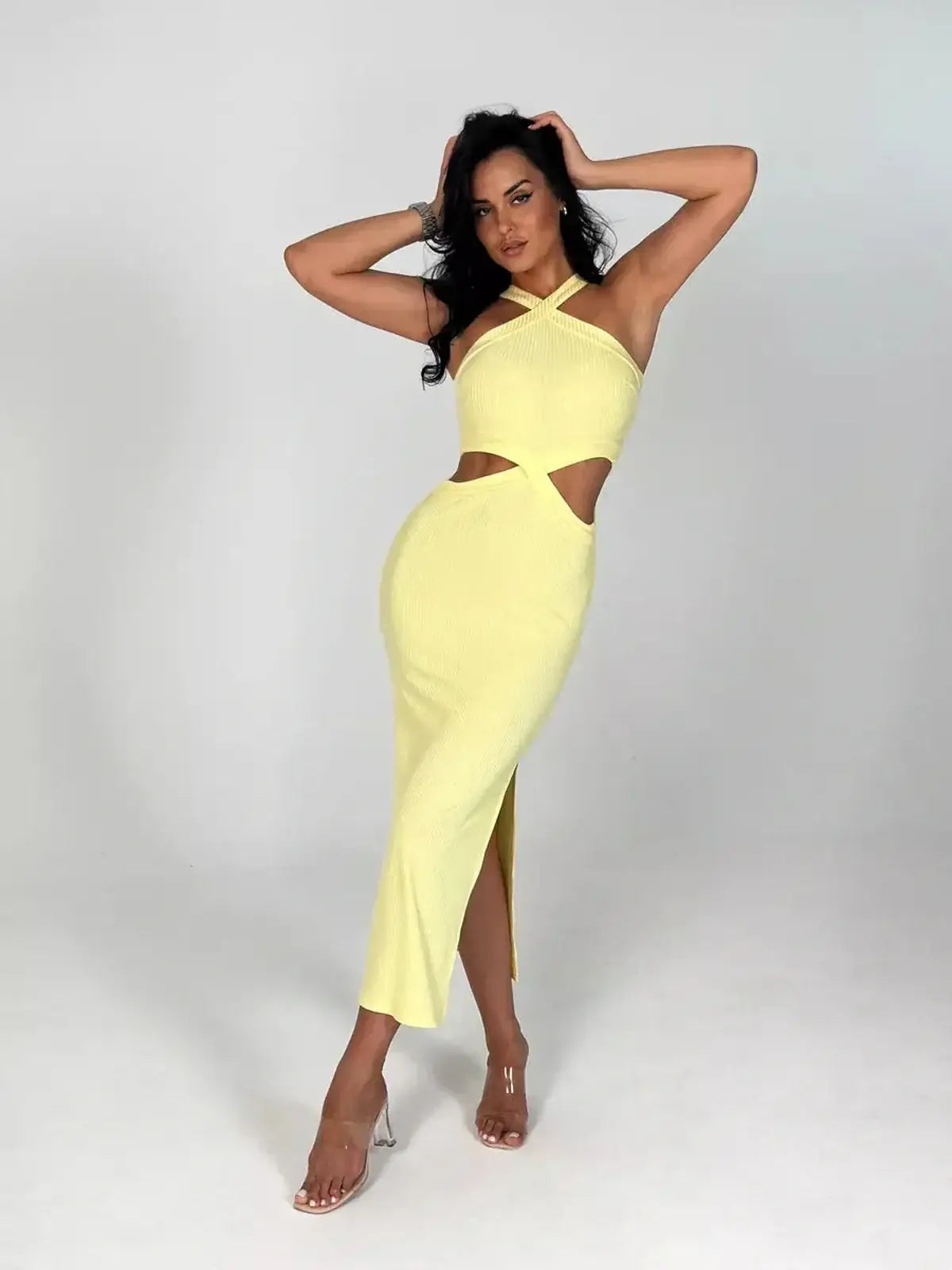 Model showcasing the Sunlace Midi Dress in pastel yellow, featuring modern cutouts and a sculpted silhouette.