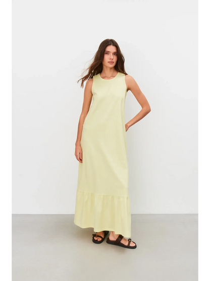 Model wearing a sleeveless Sunrise Maxi Dress in light lemon, showcasing a relaxed fit and gathered hem for summer elegance.