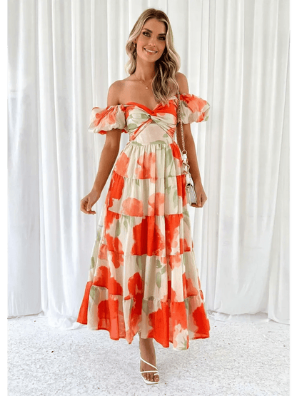 Woman in a vibrant off-shoulder maxi dress with tiered ruffles and floral patterns, perfect for sunny days.