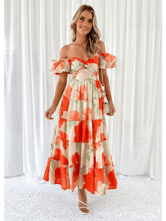 Woman in a vibrant off-shoulder maxi dress with tiered ruffles and floral patterns, perfect for sunny days.