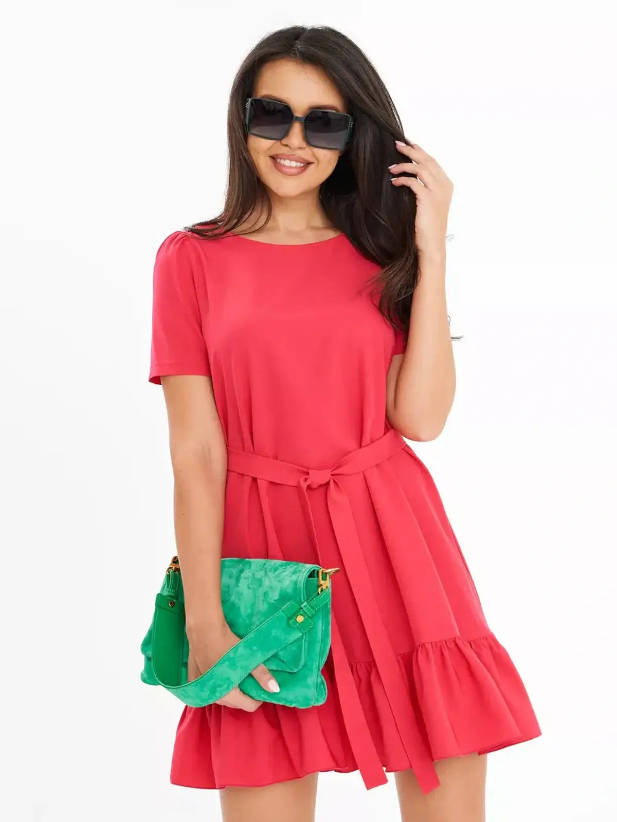 Model wearing a vibrant coral red A-line summer dress with a ruffled hem and a green handbag.
