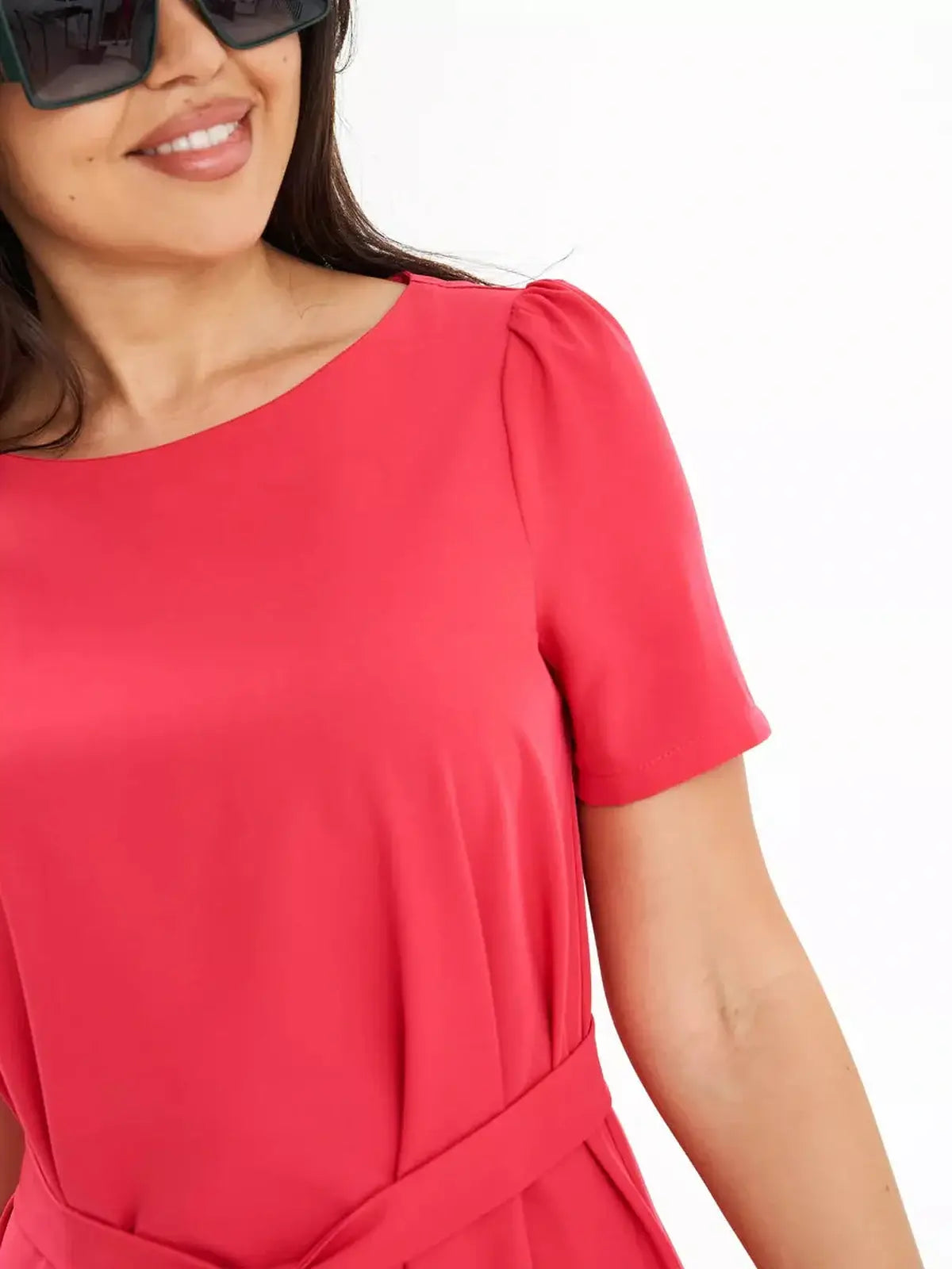 Model showcasing a vibrant coral red A-line dress with short sleeves and a self-tie belt.