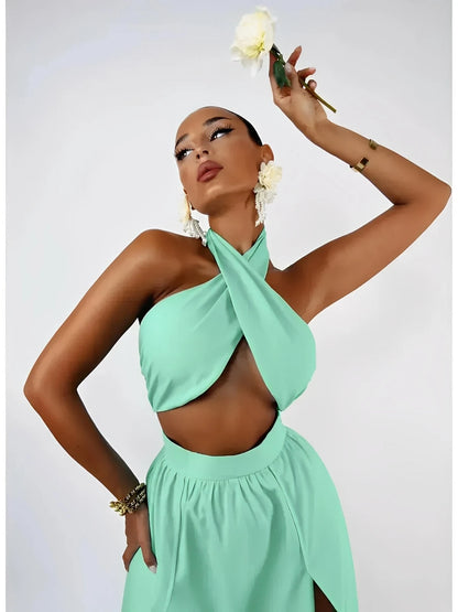 Model in a mint halter crop top and high-slit maxi skirt from the Tiffany Breeze Set, holding a flower.