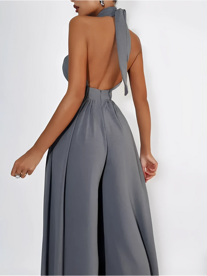 Back view of a grey twist halter jumpsuit featuring an open back and wide-leg design, showcasing elegance and sophistication.