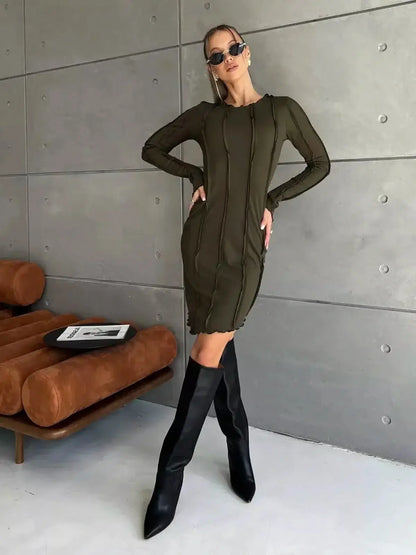 Olive green Urban Edge mini dress with long sleeves and contrast-stitch paneling styled with knee-high boots.